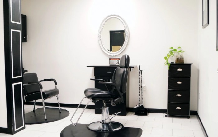 A minimalist hair salon interior with a stylish barber chair and mirror.