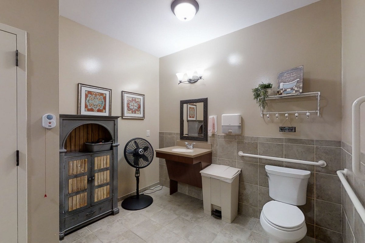 A well-decorated bathroom with a vintage cabinet, wall artwork, and essential amenities.
