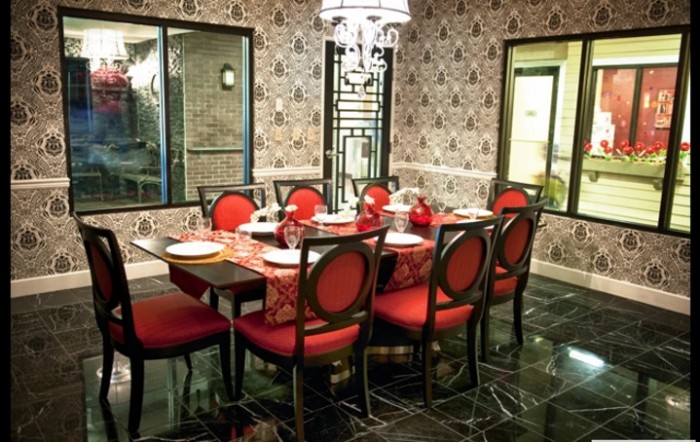 Elegant dining room with red upholstered chairs and a beautifully set table.