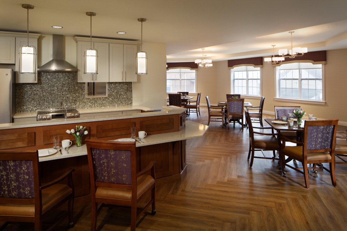 A modern kitchen and dining area with wooden flooring and elegant furniture.