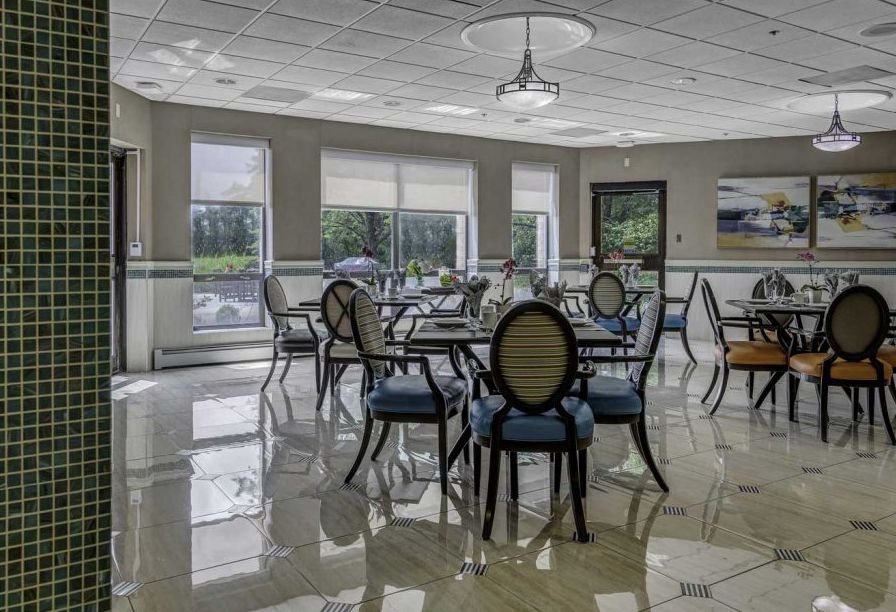 A spacious and well-lit dining room with neatly arranged tables and chairs.