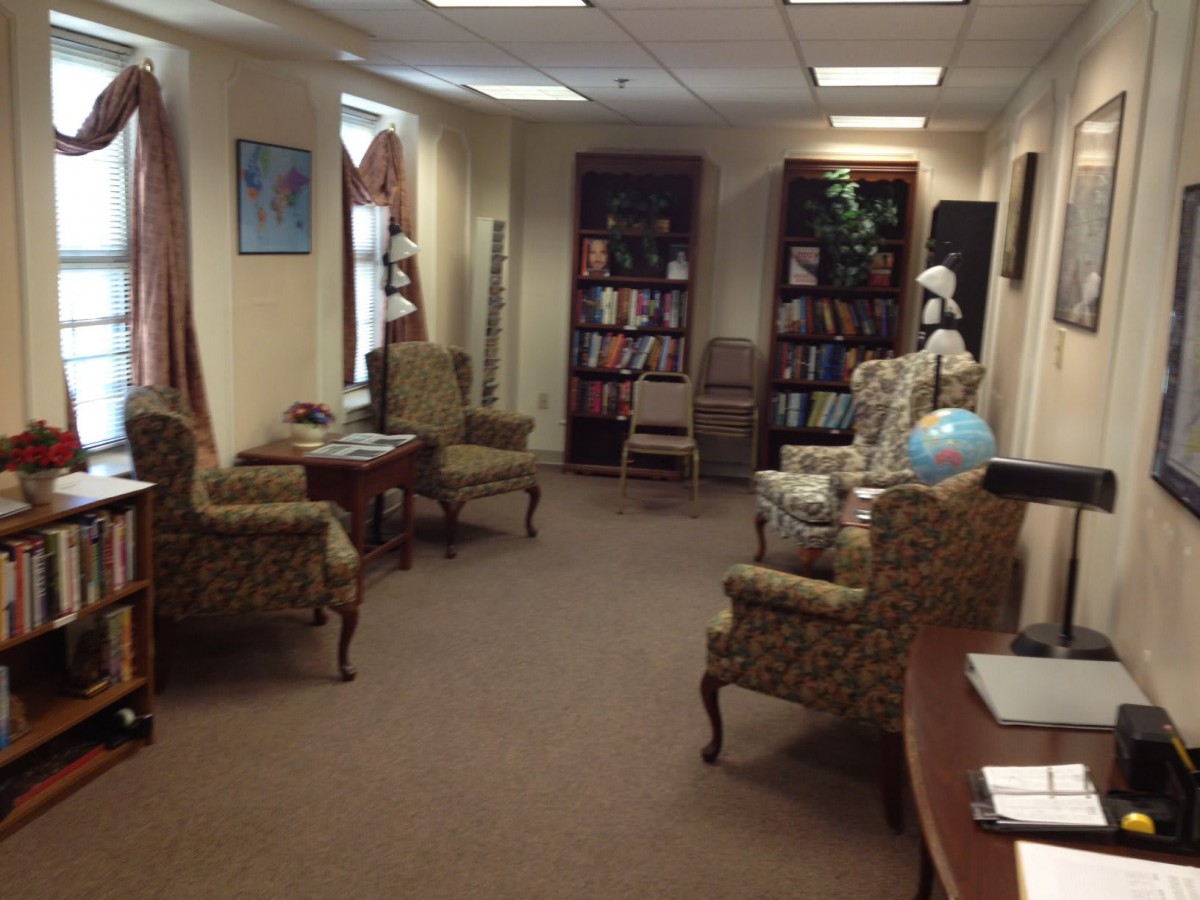 A cozy library reading room with armchairs and bookshelves.