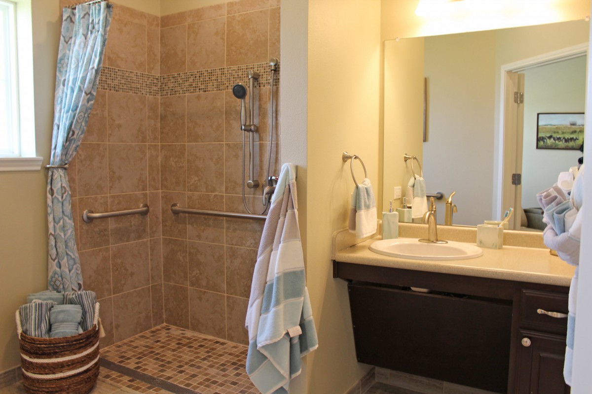 A modern bathroom featuring a tiled shower area and a sleek sink with a mirror.