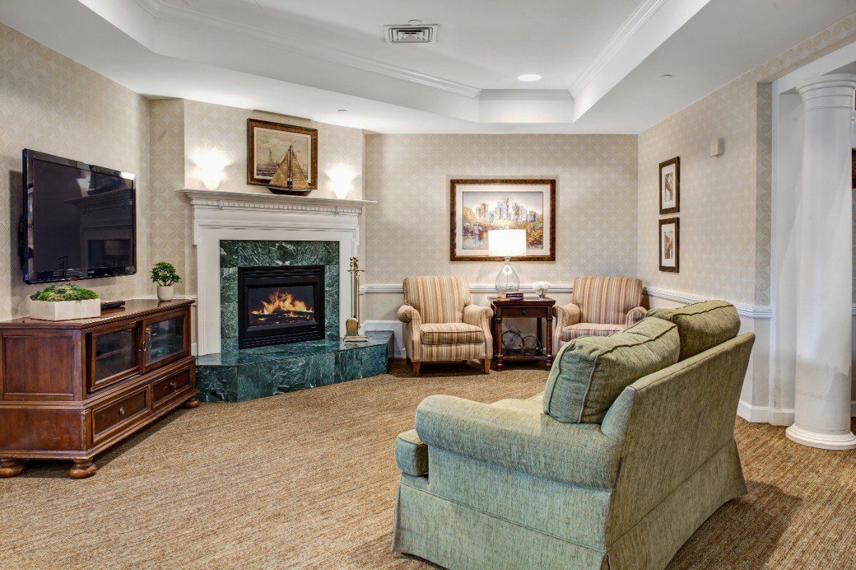 A cozy living room featuring a fireplace, sofa, and armchairs with elegant decor.
