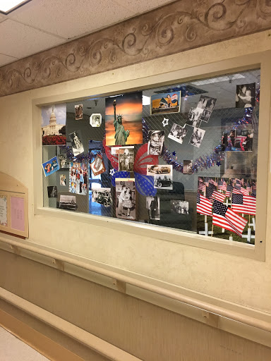 A colorful collage of photographs and flags displayed in a hospital hallway.