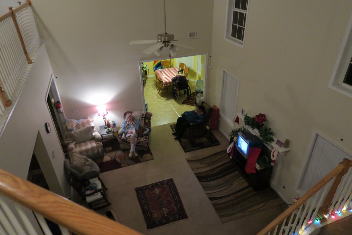 A cozy living room with people relaxing and watching TV.