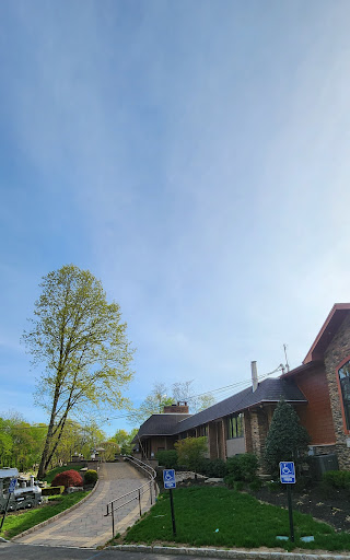 A serene view of a house surrounded by lush greenery and a clear blue sky.