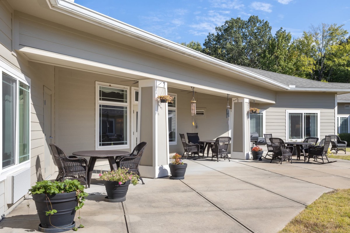 A spacious patio with outdoor furniture and potted plants on a sunny day.