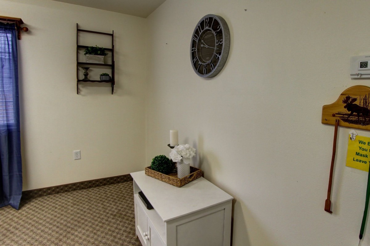 A cozy interior corner featuring a small white table with decorative items and wall art.