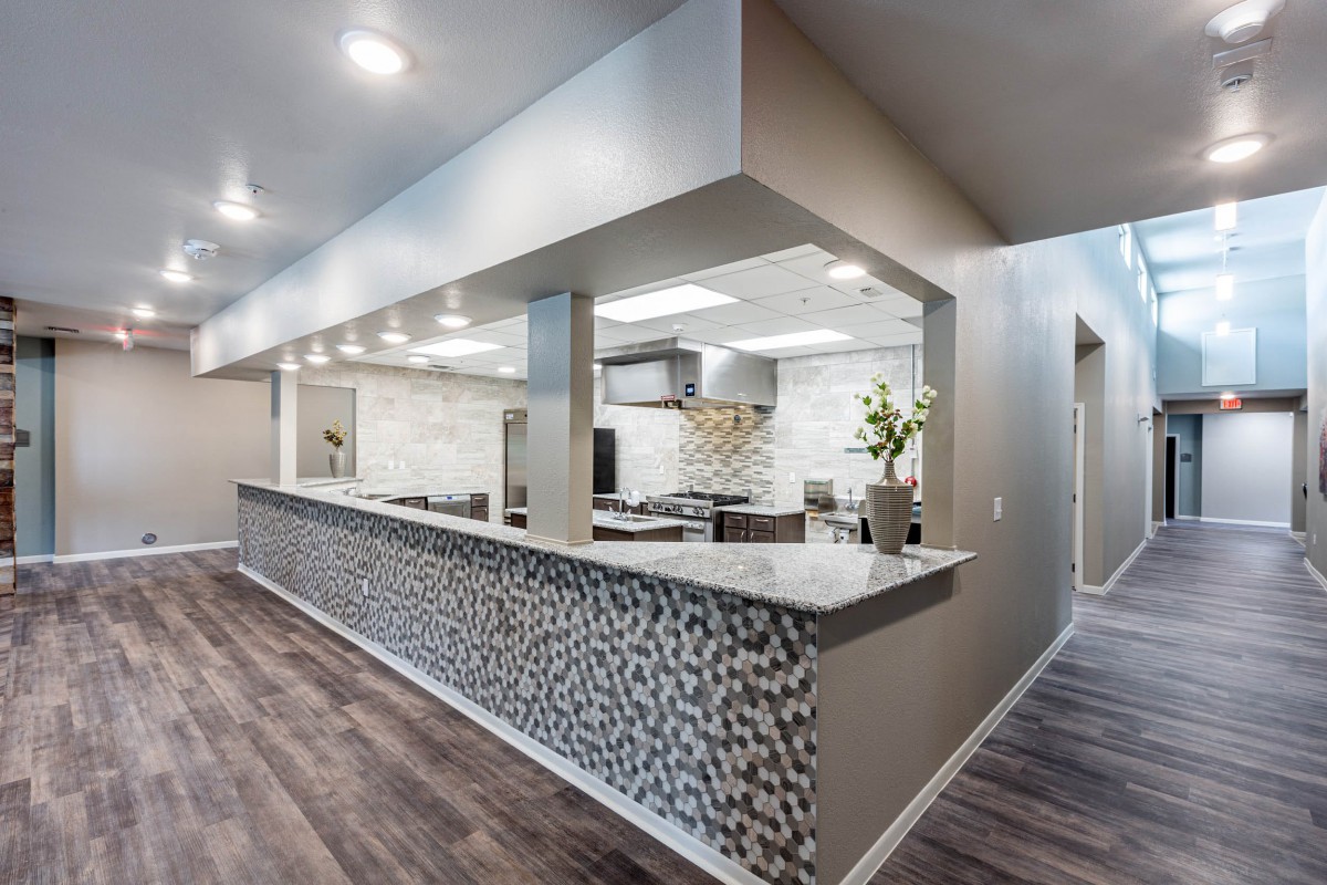 A modern kitchen with an open layout, featuring a textured countertop and recessed lighting.