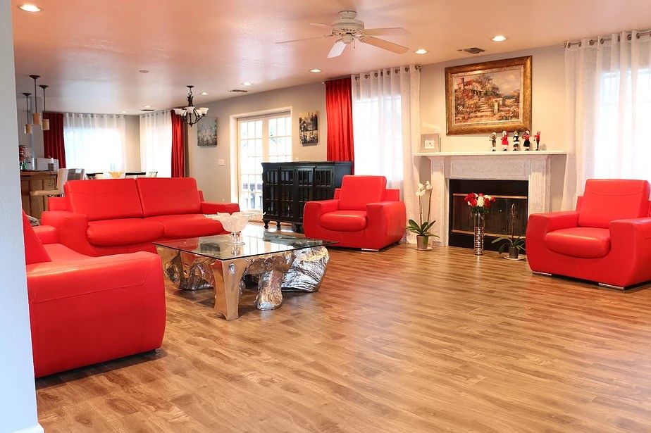A modern living room with vibrant red furniture and a cozy fireplace.
