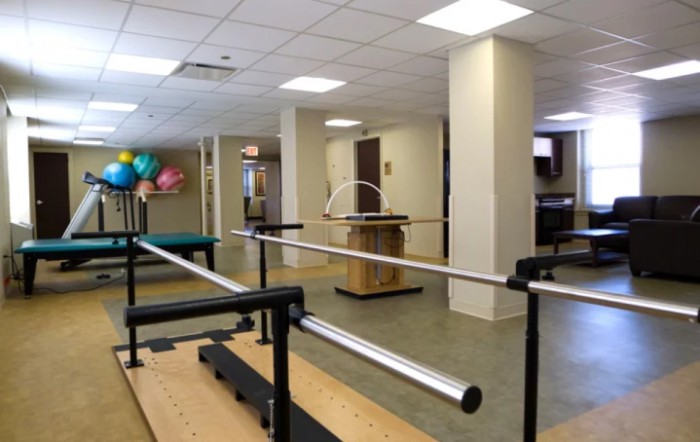 A rehabilitation center with physical therapy equipment and parallel bars.