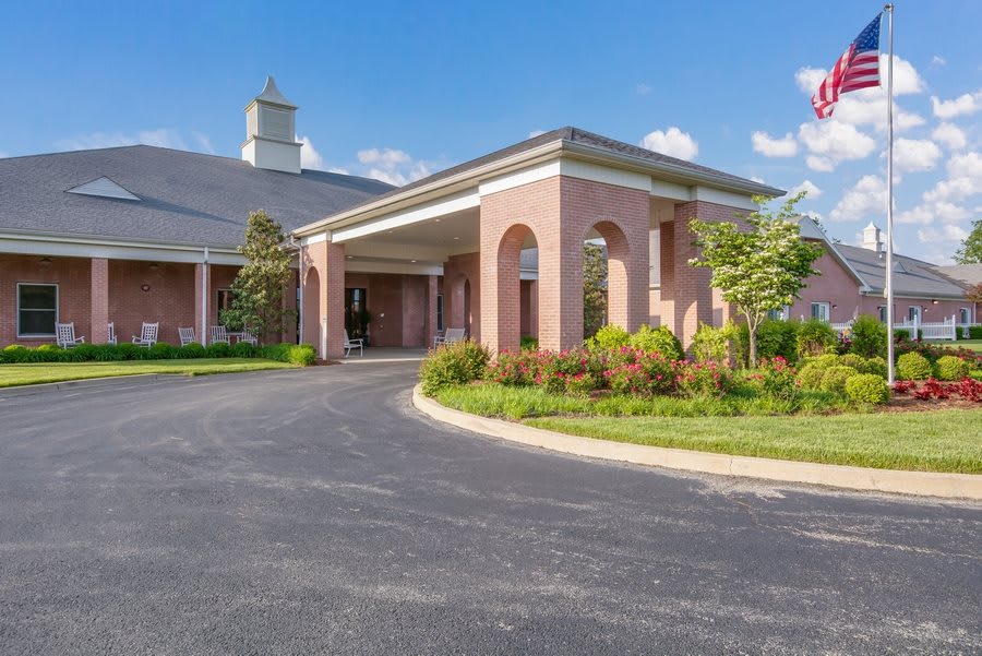 A brick church building with an arched entrance and landscaped surroundings.