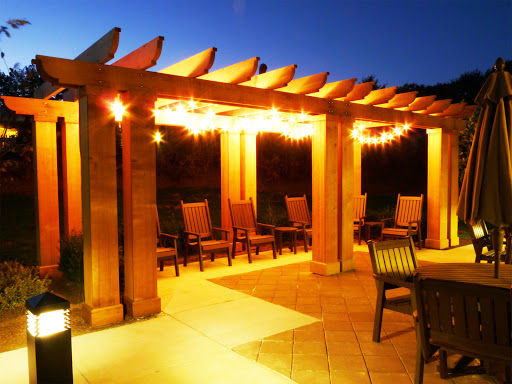 A cozy patio area with a beautifully lit pergola, perfect for evening gatherings.
