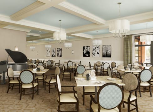 An elegant dining room with neatly arranged tables and chairs, featuring chandeliers and tasteful decor.