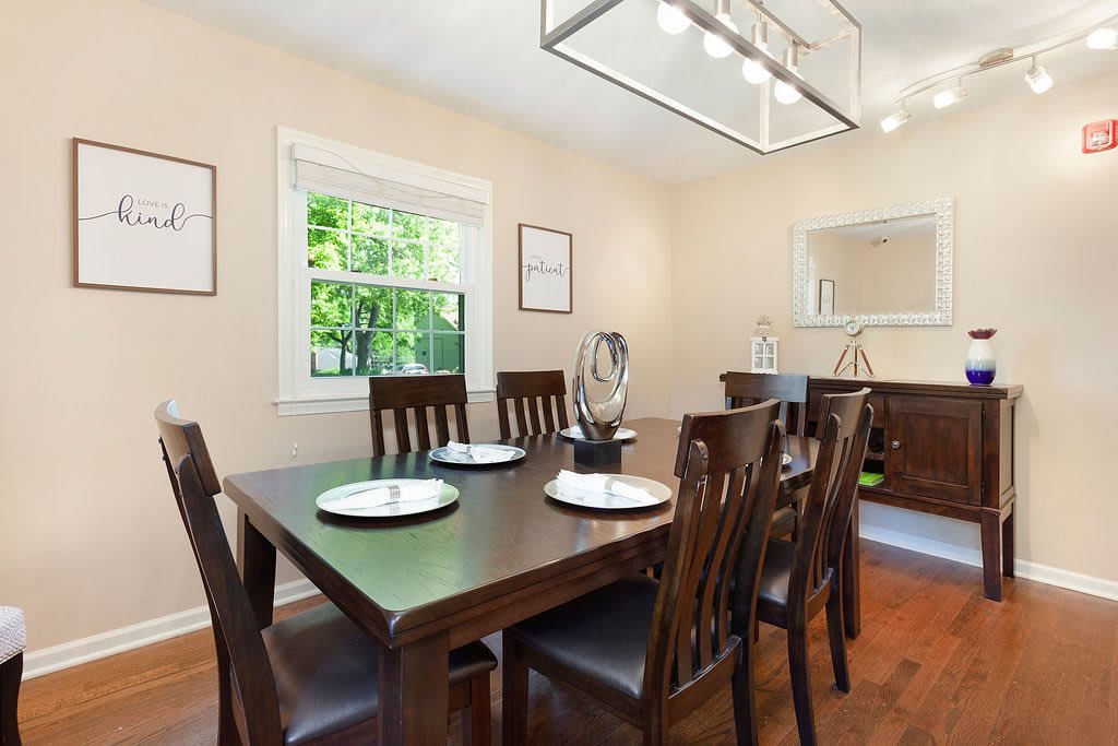 A modern dining room with a wooden table set and elegant decor.