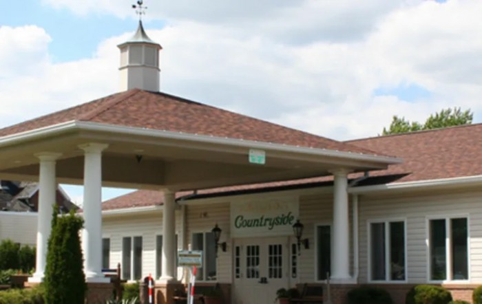 A building entrance with a cupola and red roof.