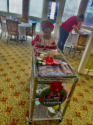 A child joyfully pushes a cart filled with holiday treats and decorations.