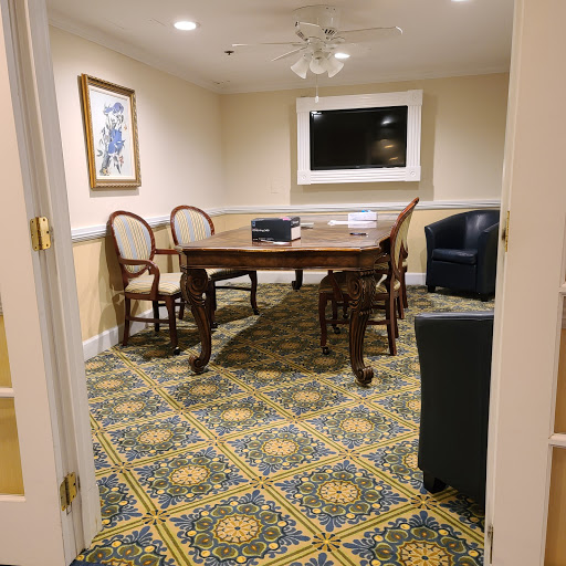 A cozy meeting room featuring a wooden table, chairs, and a television.