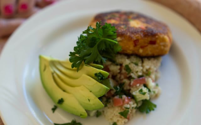 A gourmet vegetarian dish featuring sliced avocado and quinoa salad.
