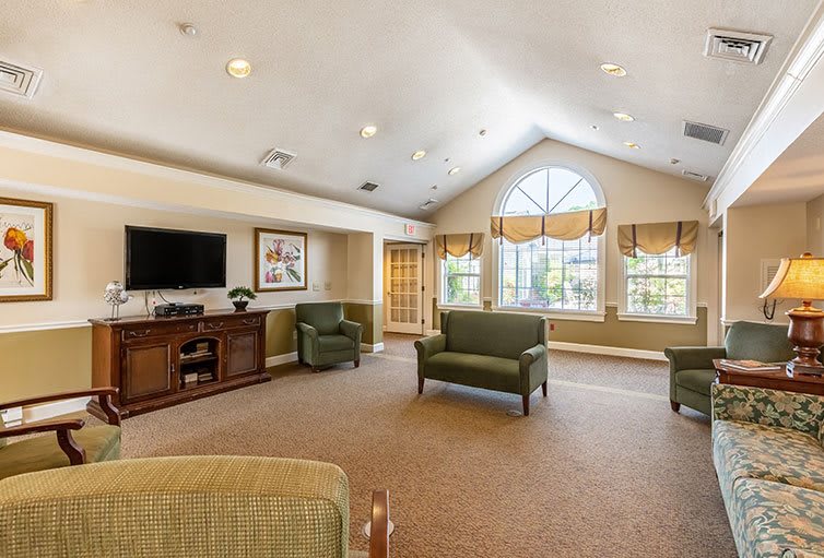 A spacious living room with comfortable seating and a large window.