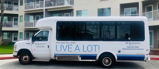 A bus with a motivational slogan 'LIVE A LOT!' displayed on its side.