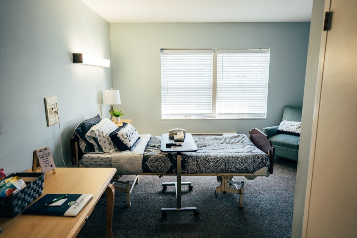 A tidy hospital room with a comfortable bed and medical equipment.