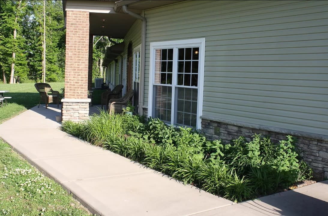 A building exterior with a pathway and landscaped garden.