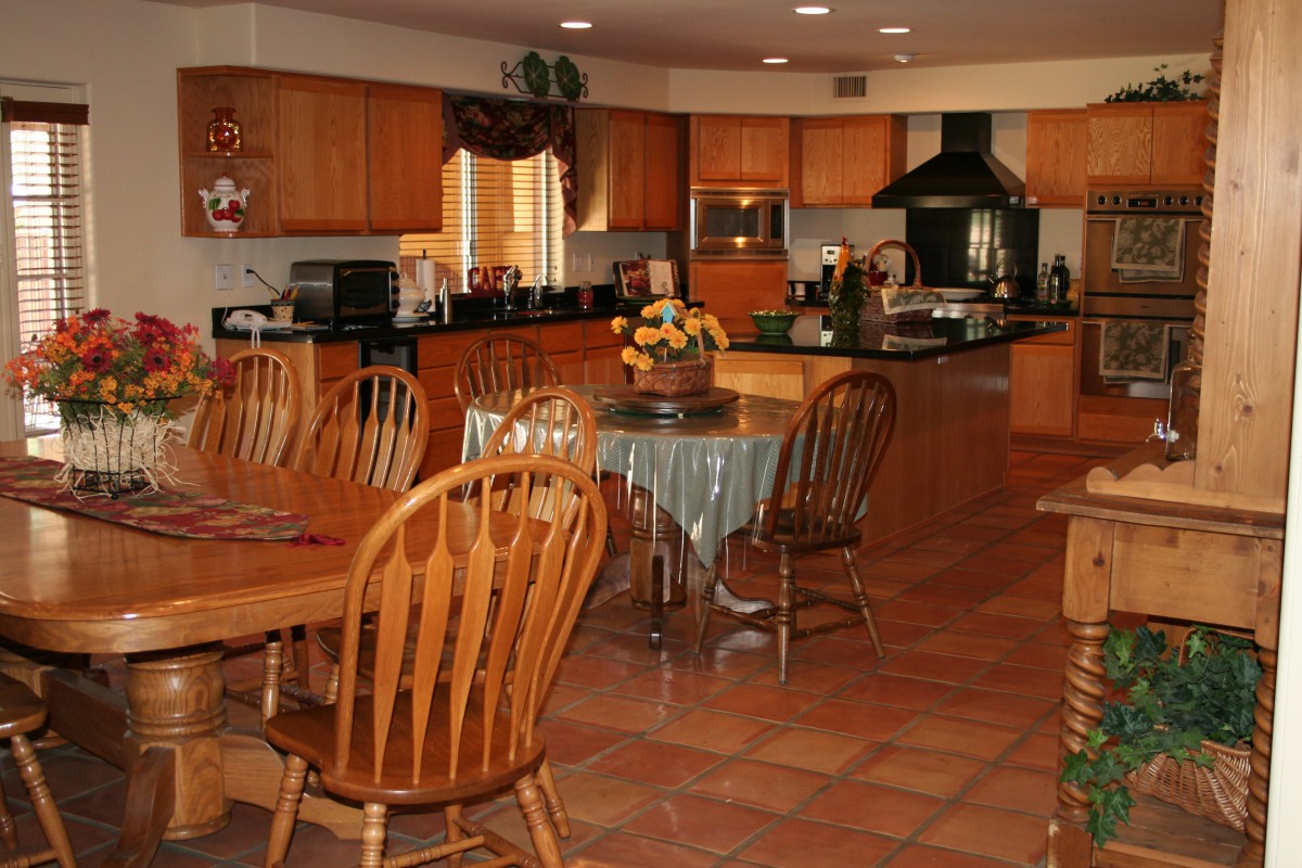 A spacious kitchen and dining area with wooden furniture and modern appliances.