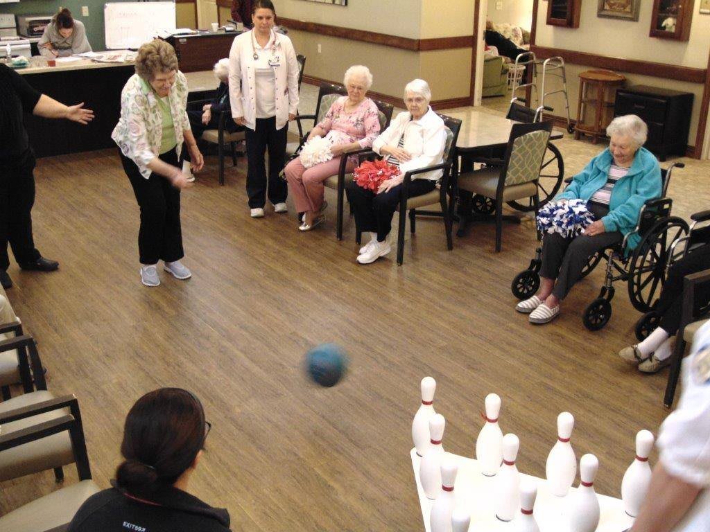 A group of seniors enjoying a game of indoor bowling.