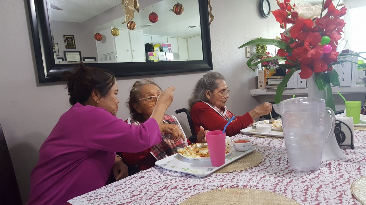 A family gathers around a table enjoying a meal together.