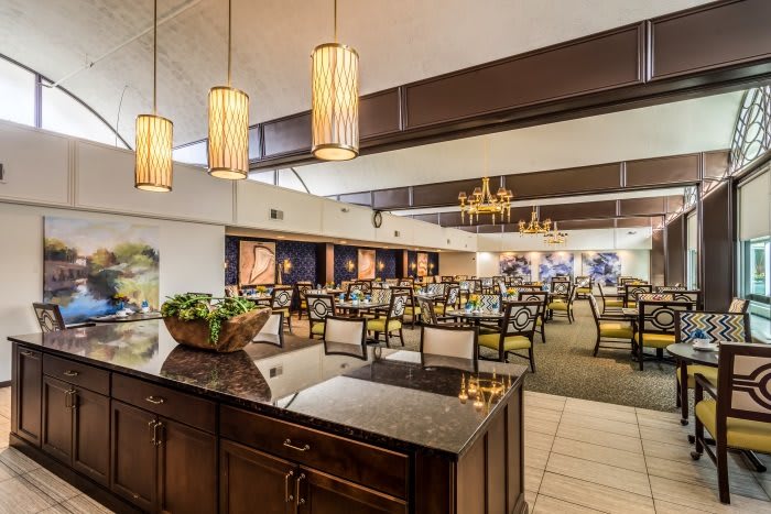 Spacious and elegantly designed restaurant interior with well-arranged tables and warm lighting.