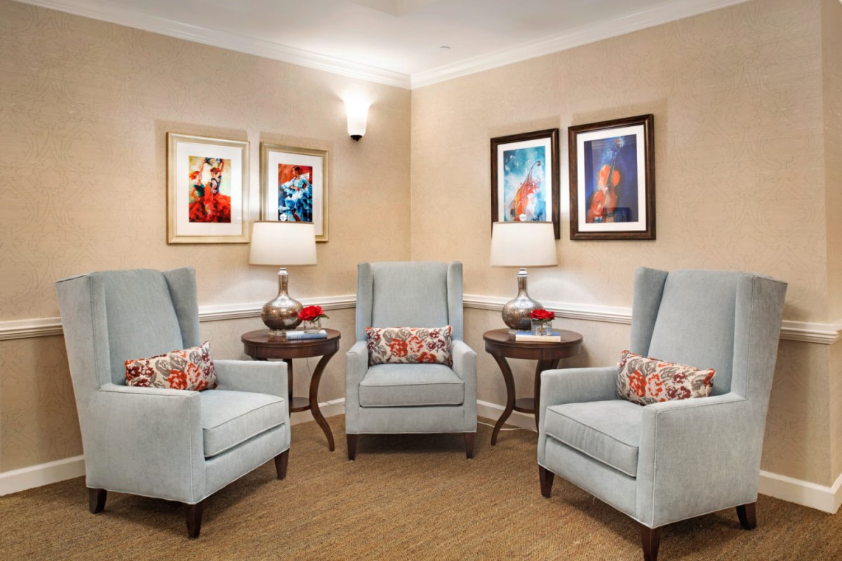A cozy living room setup with armchairs, side tables, and decorative wall art.