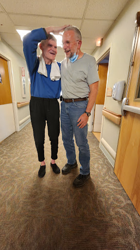 A supportive moment shared between two individuals in a hospital corridor.