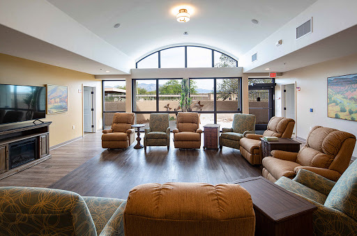 A spacious and sunlit lounge area featuring comfortable recliners, designed for relaxation.