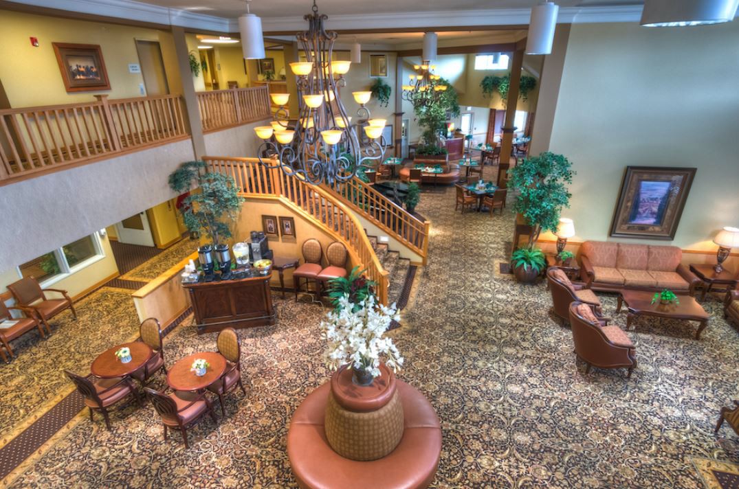 Spacious hotel lobby with elegant staircase and comfortable seating.