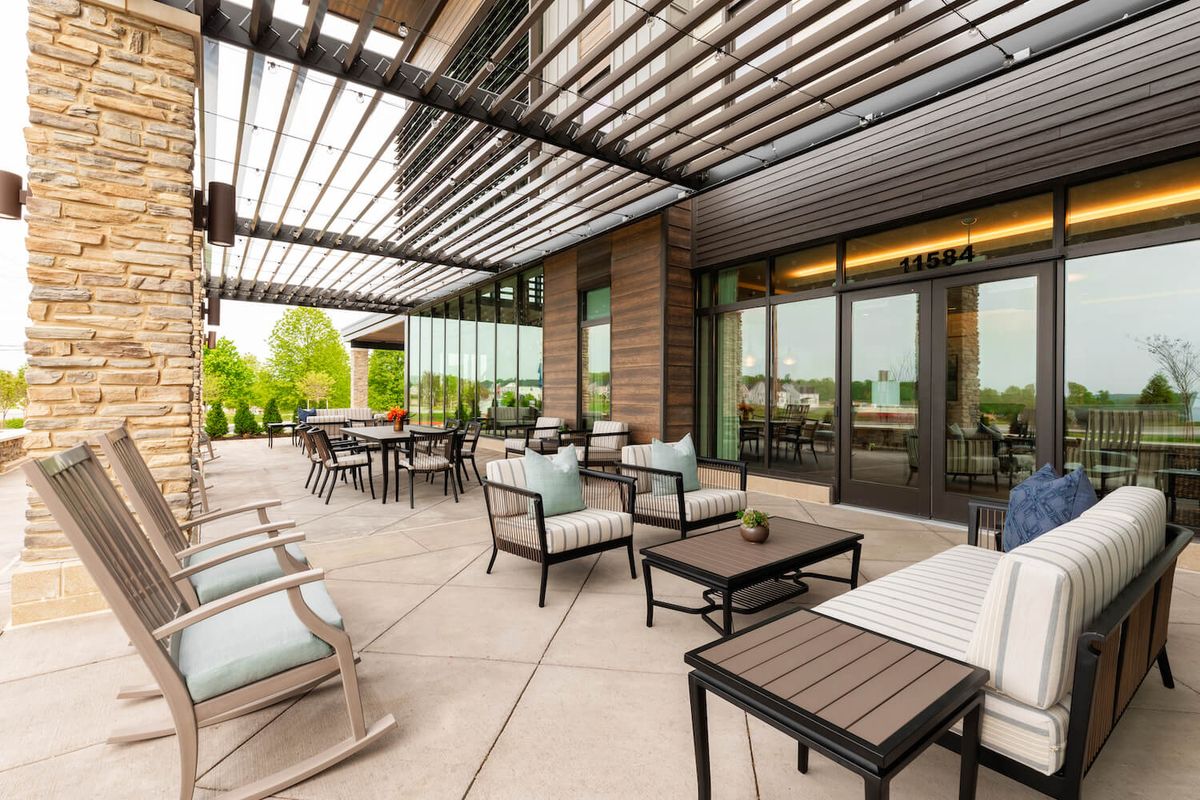 A modern patio with comfortable outdoor seating under a pergola.