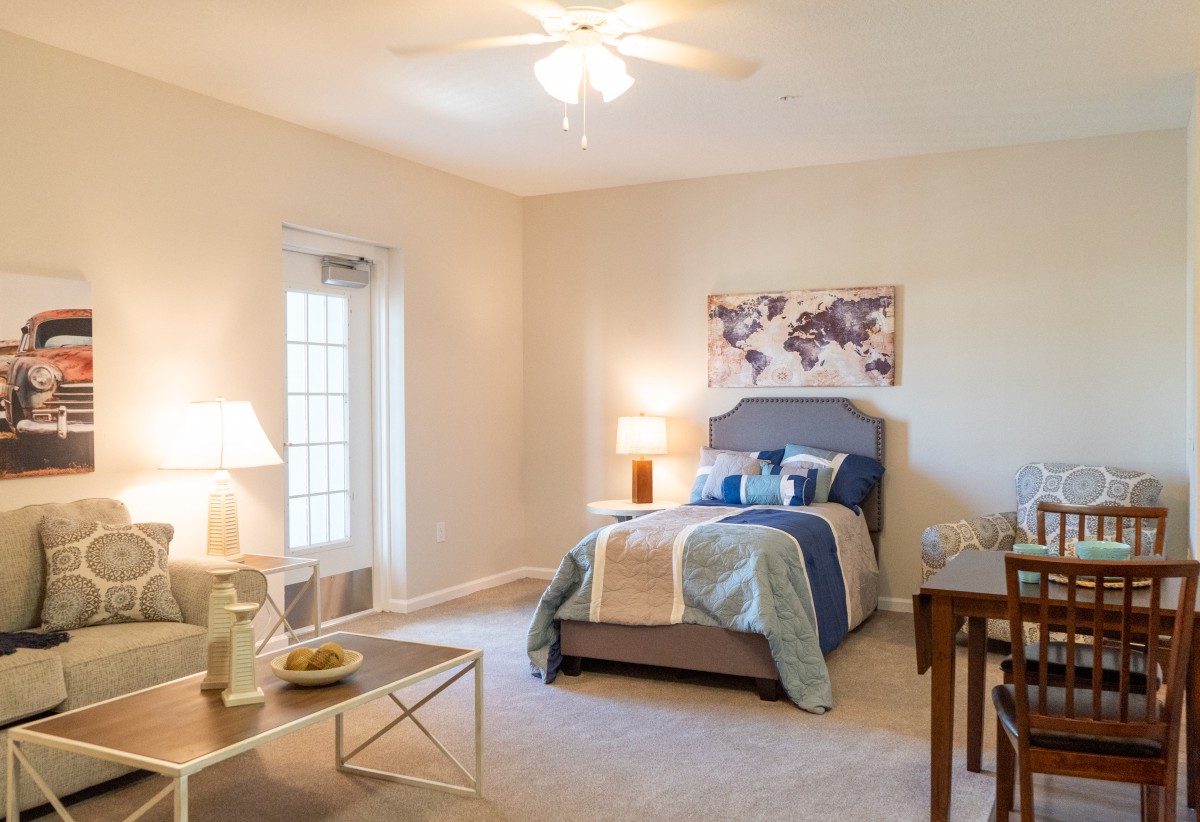 A cozy bedroom with a neatly made bed, soft lighting from lamps, and tasteful decor.