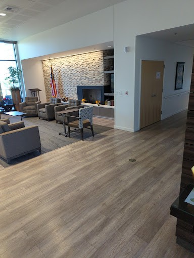 A modern waiting area with comfortable seating and a wooden floor.