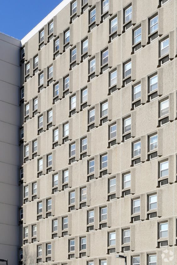 A repetitive pattern of windows on an urban apartment building facade.
