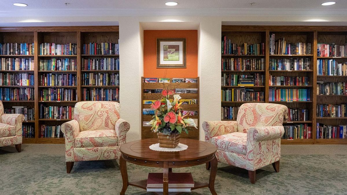 A cozy library corner with armchairs and bookshelves.