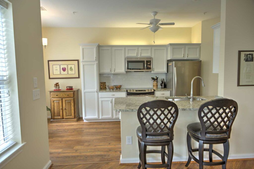 Modern kitchen with bar stools and stainless steel appliances.