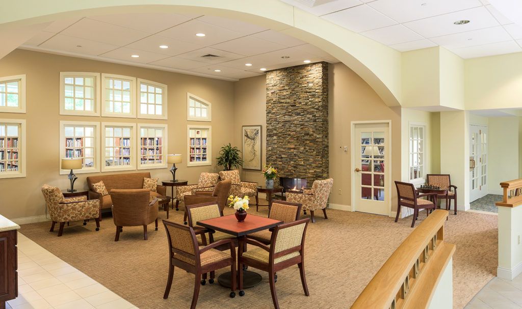 A cozy and elegantly decorated living room with comfortable seating, tables, and a stone accent wall.