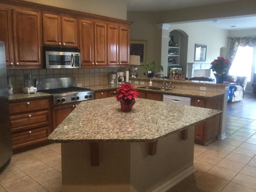 A kitchen featuring a granite island and wood cabinets.