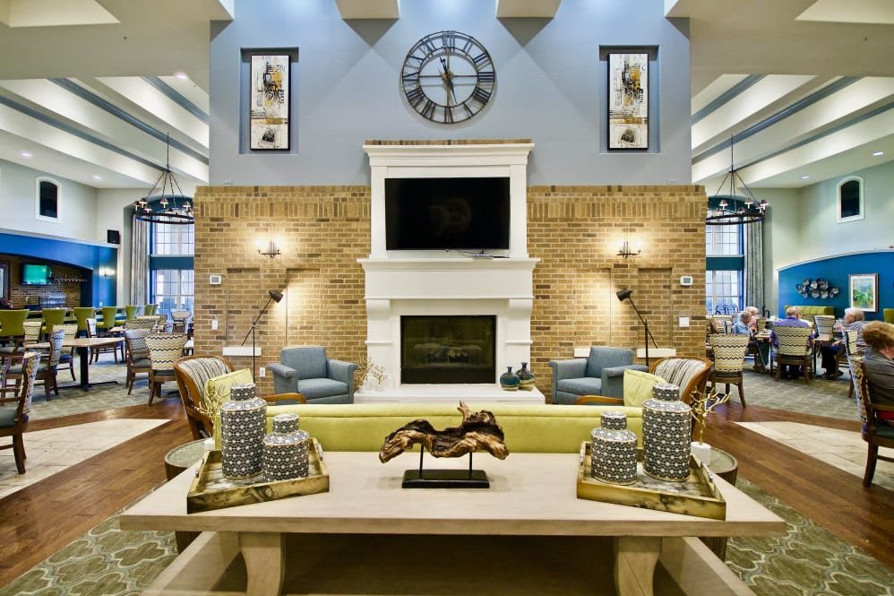 A stylishly decorated living room featuring a central fireplace, modern furniture, and elegant decor.