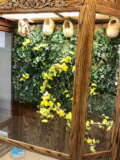 A serene indoor space featuring vibrant yellow flowers and decorative wooden elements.