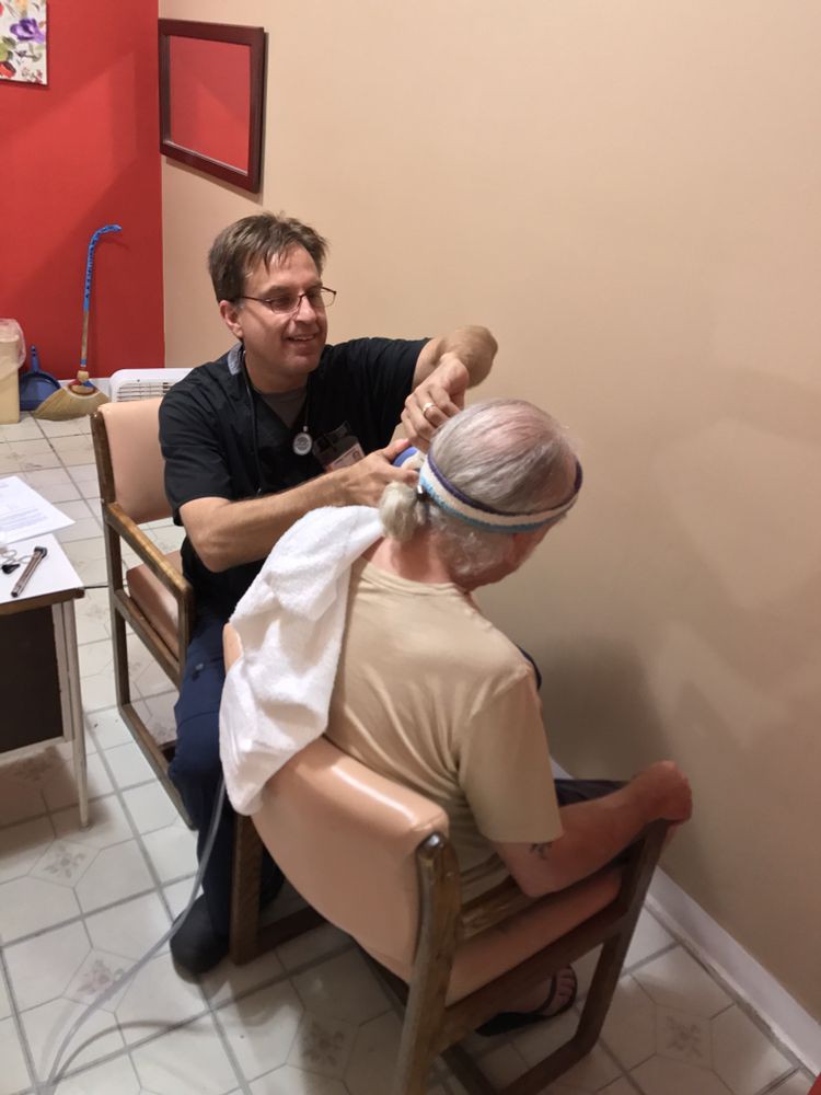A barber giving a haircut to a customer seated in a salon.