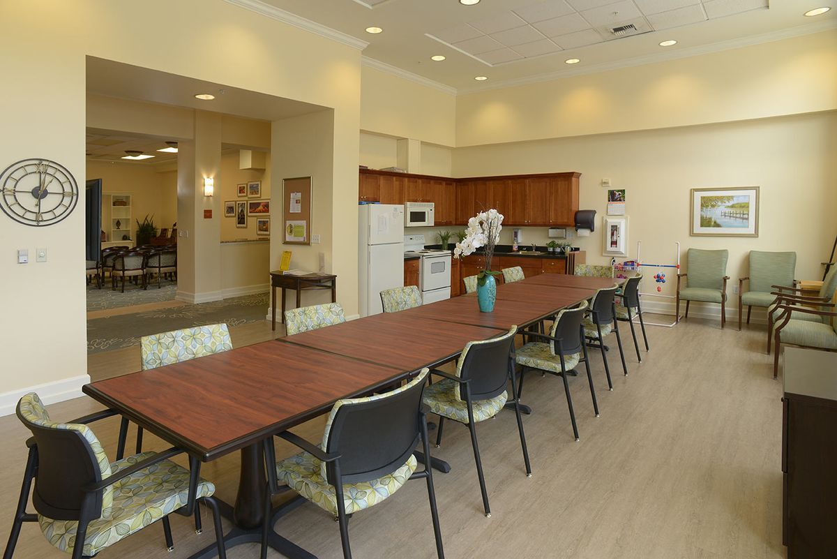 A modern kitchen and dining area with a long table and chairs.