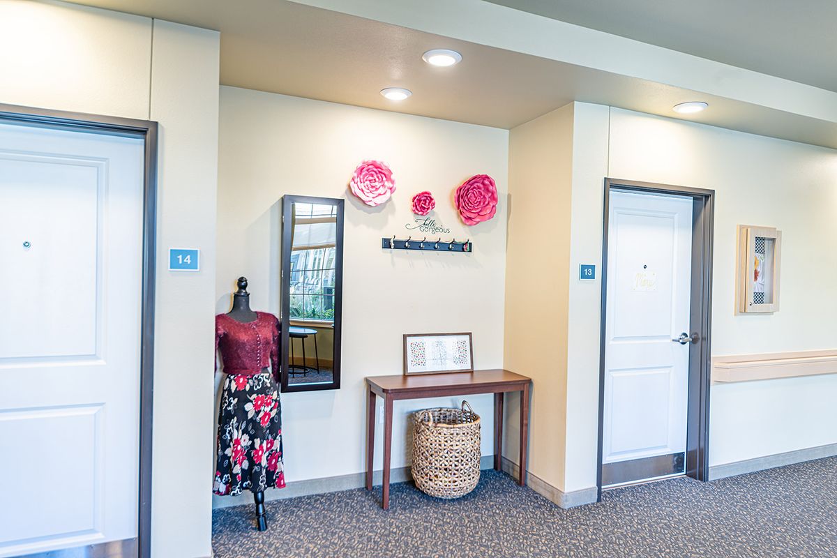 A stylish interior hallway with decorative elements including a mannequin, a mirror, and wall art.