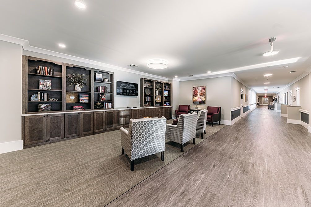 A modern lounge area featuring comfortable seating and bookshelves.